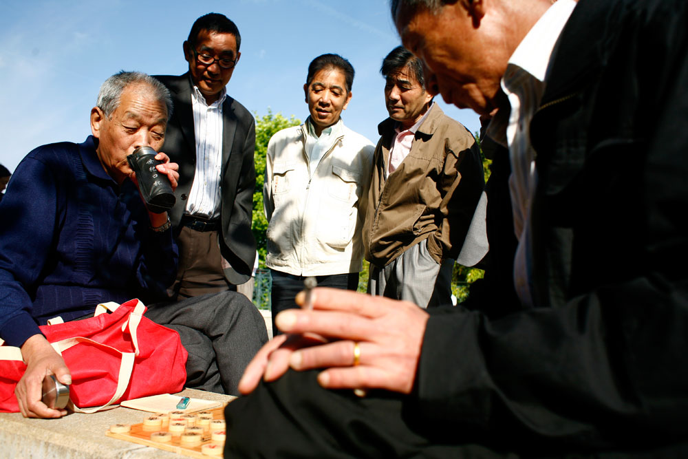 Les yie-yie - les grands-pères - se retrouvent au parc autour d'une tasse de thé bouillante et d'un plateau de mahjong.