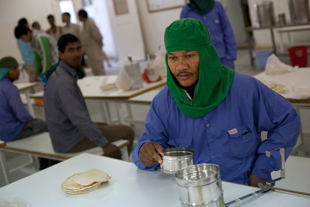 Camp Al Nakhla. Avant de partir sur les chantiers, les ouvriers viennent boire un thé et se servir un bol de riz dans la cantine du camp.