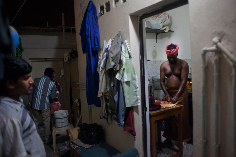 Camp Al Kharayej, à la périphérie de Doha. Un ouvrier fait la cuisine pour les autres habitants de sa chambre.