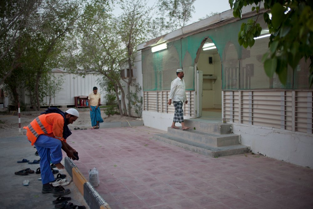 Camp Al Nakhla. Retour des ouvriers à la tombée du jour pour l'heure de la prière à la mosquée.