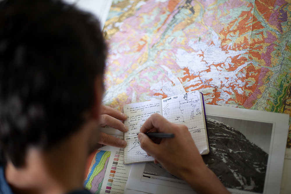 Julien travaille sur une carte géologique avec les notes qu’il a prises sur le terrain, à la Mer de Glace.