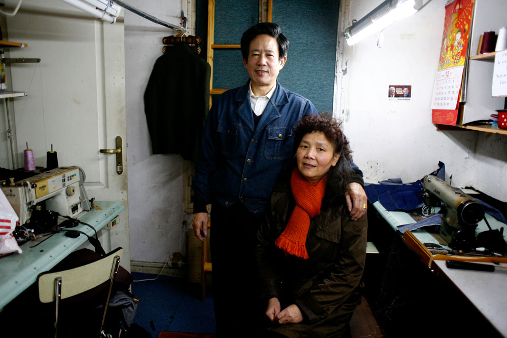 Xiaoqiu et Zhangdacheng sont arrivés de la province du Wenzhou en 2001. Ils n'ont pas vu leurs deux enfants depuis leur départ.
Ils travaillent en couple, dans leur petit logement d'Aubervilliers comme sous traitants d'un atelier de confection. Ils cousent des manteaux et des vêtements en cuir, payes entre 7 et 8 euros la pièce.