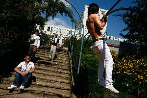 Des jeunes chinois du quartier font de la musculation au pied des tours, place Marcel Achard.